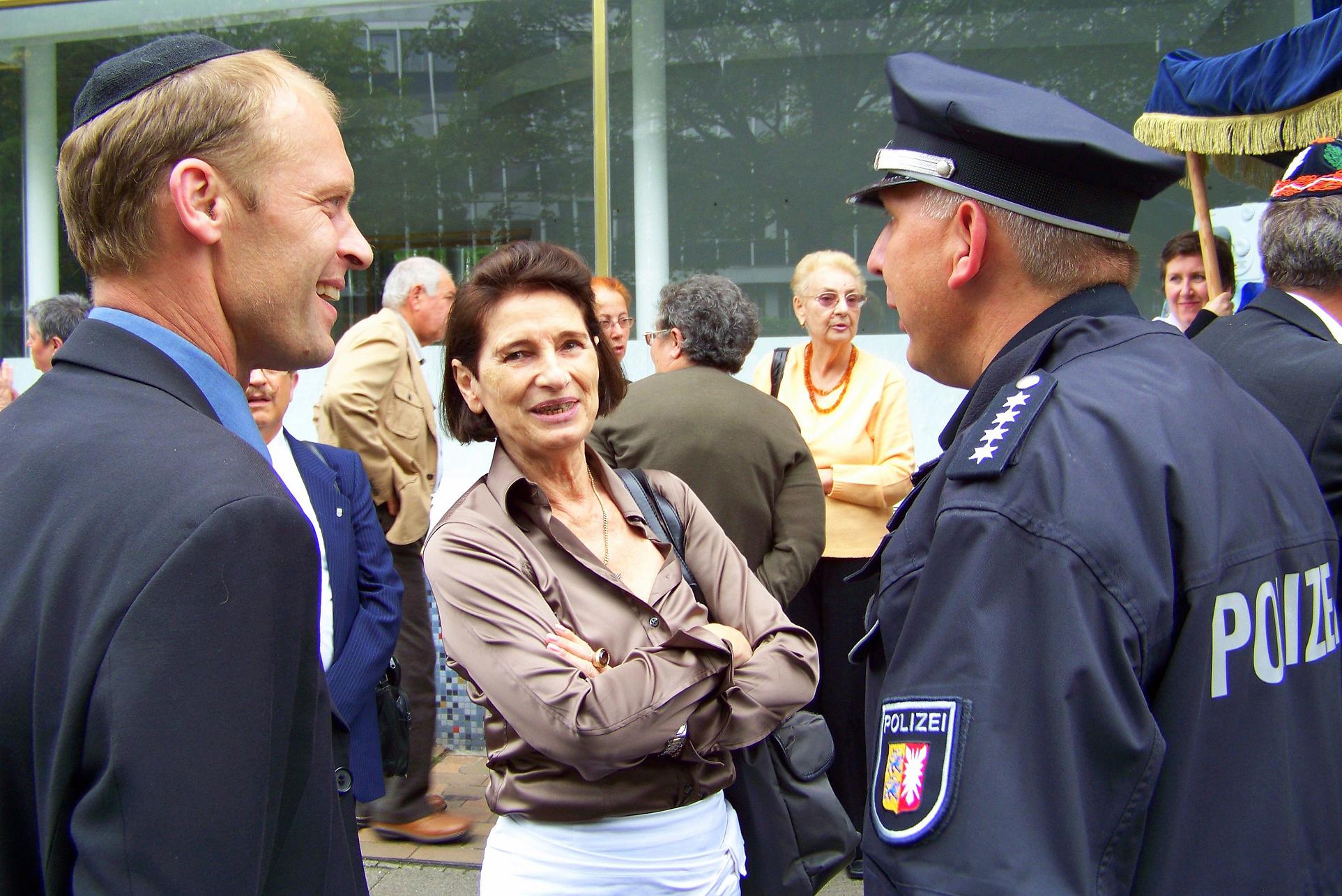Fröhliche Einweihung der neuen Gemeinderäume im Flamweg - die Vorsitzende Alisa Fühlbrügge (Mitte) im Gespräch mit Walter Blender (links) und den Helfern der örtlichen Polizei